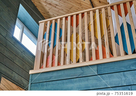 Multicolored wooden stair railings of the second floor in a modern wooden house 75351619