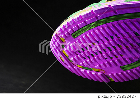 Textured pink sole of sports running shoes on a black background. 75352427