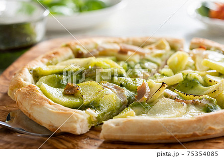 じゃがいもとベーコンのバジルソースのピザの写真素材
