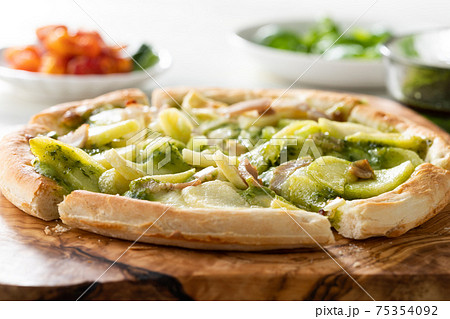 じゃがいもとベーコンのバジルソースのピザの写真素材