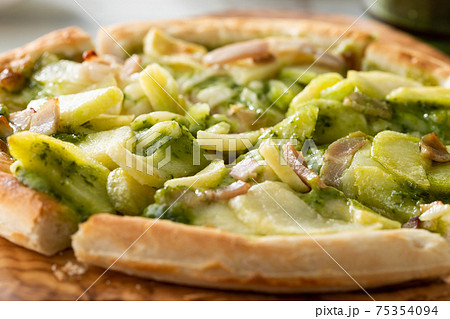 じゃがいもとベーコンのバジルソースのピザの写真素材