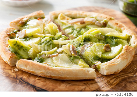 じゃがいもとベーコンのバジルソースのピザの写真素材