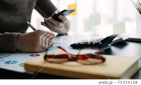 Business woman working in finance and accounting Analyze financial budget in the office 75354138