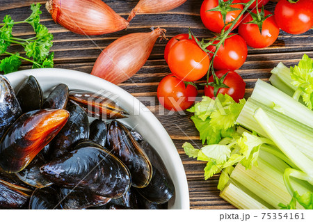 Mussels with parsley in a bowl on a wooden board. Seafood. 75354161