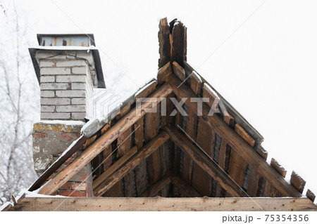 Old abandoned wooden house fragment, rooftop and chimney Old abandoned wooden house fragment, rooftop and chimney 75354356