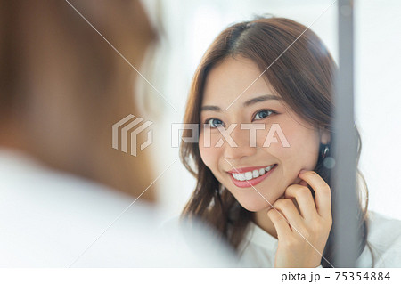 鏡を見るきれいな女性 75354884