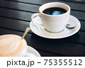 Cappuccino with latte art and a cup of black aromatic coffee on wooden table 75355512