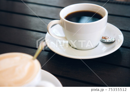 Cappuccino with latte art and a cup of black aromatic coffee on wooden table 75355512