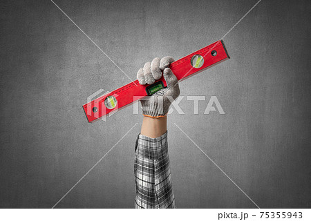 hand holds a construction tool spirit level 75355943