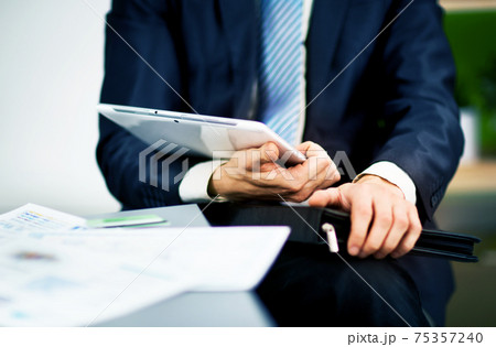 Businessman hands are holding the touch screen device. 75357240