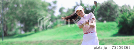 Woman golfer makes hit with golf club. 75359865