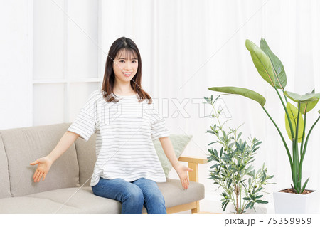 部屋のソファに座って深呼吸をする若い女性 部屋のソファに座って深呼吸をする若い女性 75359959