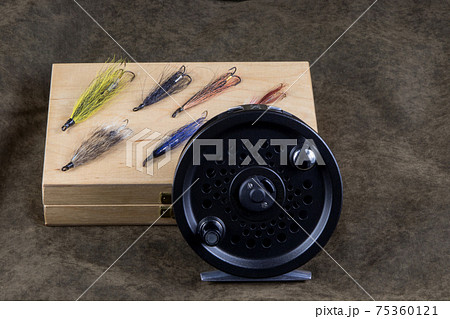 Fly Reel and Wooden Fly Box with Salmon Flies on an Outdoor Coat 75360121