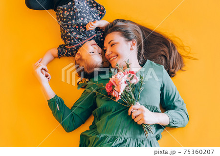 Daughter gives gift to her mother. Congratulations to the parents on the holiday Daughter gives gift to her mother. Congratulations to the parents on the holiday 75360207