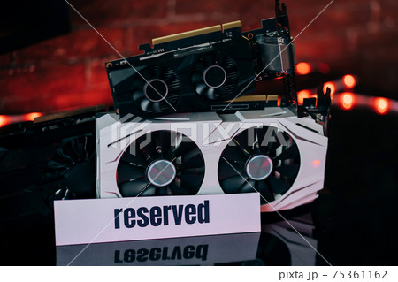 Graphics cards of different sizes and configurations on black table under neon light. Part of computer for gaming and cryptocurrency mining Graphics cards of different sizes and configurations on black table under neon light. Part of computer for gaming and cryptocurrency mining 75361162