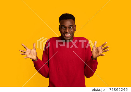 Portrait Of Cheerful African American Guy Spreading Hands In Excitement 75362246