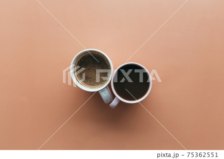Two pink and blue coffee cups on beige background Two pink and blue coffee cups on beige background 75362551