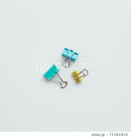 Blue and yellow paper clips on white background. Work and education concept 75362810