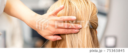 Female hairdresser styling blonde hair 75363845