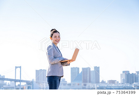 エンジニアの女性と空と高層ビル群の写真素材