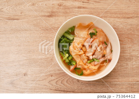 Chinese dumpling topping slice red barbrcue pork with clear soup on bowl 75364412