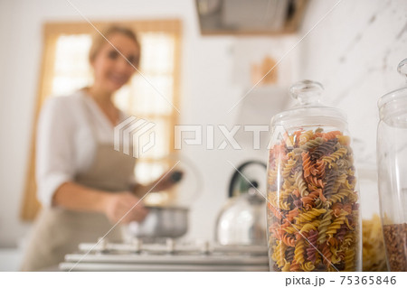 Housewife in apron cooking in the kitchen Housewife in apron cooking in the kitchen 75365846