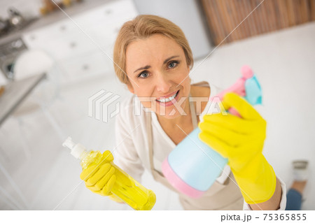 Housewife in apron and gloves looking annoyed 75365855