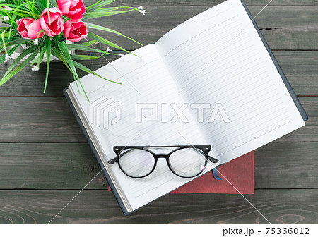 Reading glasses put on open book Reading glasses put on open book 75366012