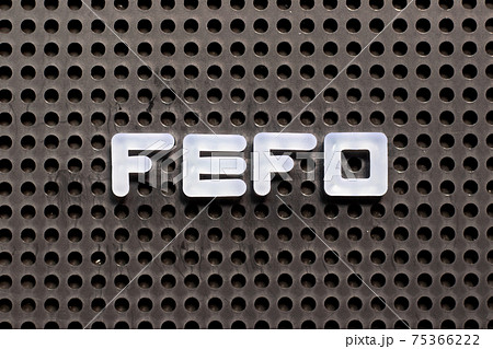 White color letter in word FEFO (first expired first out) on black pegboard background 75366222