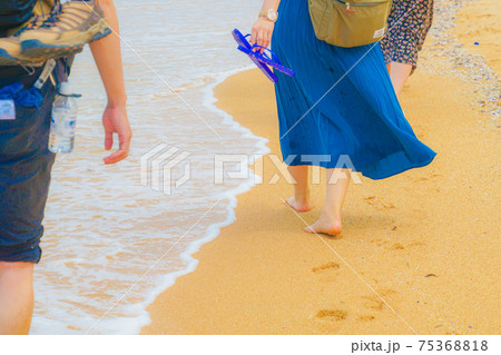 砂浜を歩く女性の足 75368818