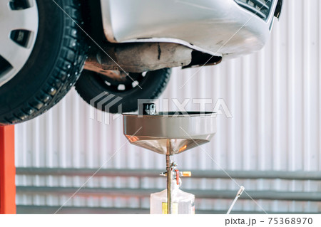 Equipment at a service station for changing the oil in an internal combustion engine. Scheduled vehicle maintenance Equipment at a service station for changing the oil in an internal combustion engine. Scheduled vehicle maintenance 75368970