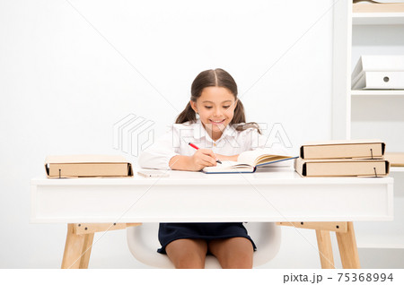 Excellent pupil. Girl child writes hometask while sit table  75368994
