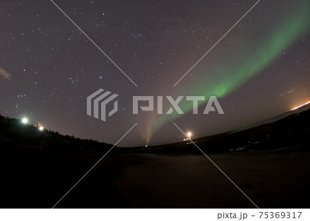 北欧アイスランドの冬期ゴロッタ(Grotta)灯台付近の公共通者上から観える満天の星と灯台とオーロラ 北欧アイスランドの冬期ゴロッタ(Grotta)灯台付近の公共通者上から観える満天の星と灯台とオーロラ 75369317