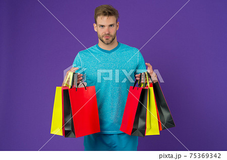 Man with shopping bags on violet background. Macho  75369342