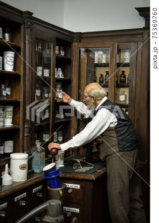Museum Past of Physic Preparation. Kiev, Ukraine, 2017. Glass phial, oil ointment, vial, herb elixir, flask, jar, pot, pill set. Aged druggist case. Rustic interior of obsolete wood storage cabinet 75369760