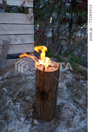 キャンプでスウェーデントーチに火を灯す 75369913