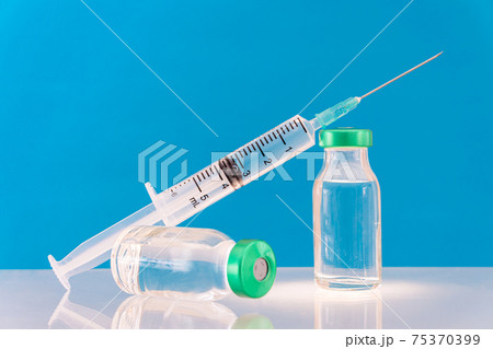 Potential trials stage concept on blue background. Close up Vials with sterile needle syringe. Research and Development, Vaccination. 75370399