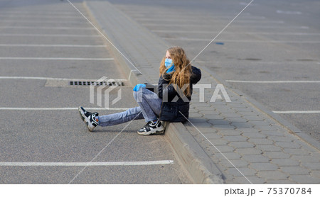 Portrait of sad Caucasian girl in face mask at the city and in the park outdoor. Coronavirus social distance quarantine. Portrait of sad Caucasian girl in face mask at the city and in the park outdoor. Coronavirus social distance quarantine. 75370784