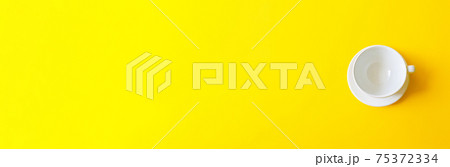 Top view of an empty white ceramic cup on a yellow background. Concept morning breakfast, drink coffee or tea. Top view of an empty white ceramic cup on a yellow background. Concept morning breakfast, drink coffee or tea. 75372334