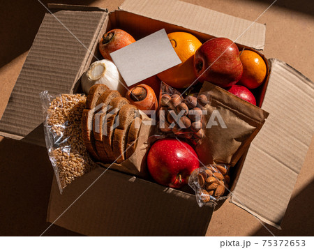 Healthy food delivery flat lay harsh shadows. Take away natural organic products.Donation box New normal online shopping Healthy food delivery flat lay harsh shadows. Take away natural organic products.Donation box New normal online shopping 75372653