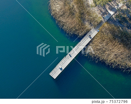 Aerial view of wood pier with fishers and their fishing rods at the Miramar lake, San Diego 75372796