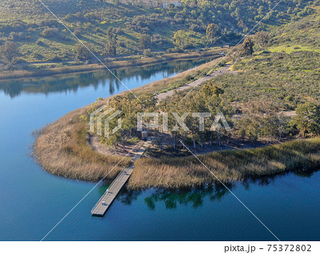 Aerial view of wood pier with fishers and their fishing rods at the Miramar lake, San Diego 75372802