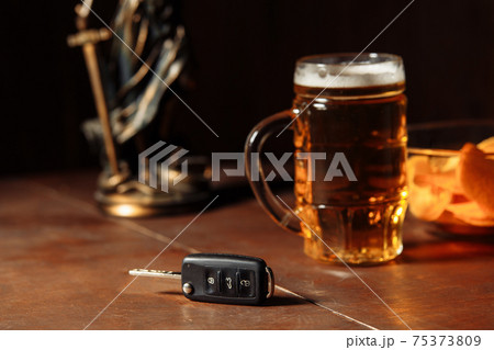 Glass of beer, car keys and lady of justice. Alcohol and car accidents concept 75373809