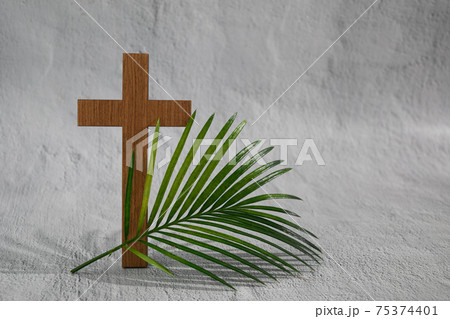 Palm sunday background. Cross and palm on grey background. 75374401