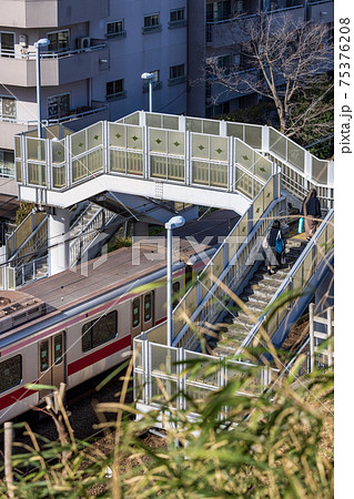 跨線橋を歩く人と通過する電車 75376208