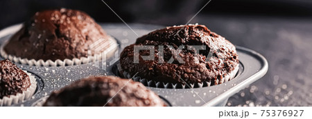 Just baked chocolate muffins in tray, homemade comfort food recipe Just baked chocolate muffins in tray, homemade comfort food recipe 75376927