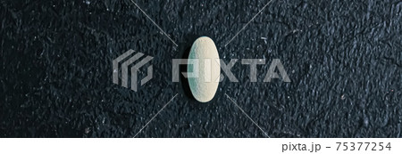 Medical pill on stone background, health and wellness 75377254