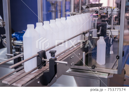 White bottles on conveyor belt of liquid filling machine 75377574