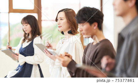 タブレットとタッチペンを使う若い女性 75377861