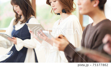 タブレットとタッチペンを使う若い女性 75377862